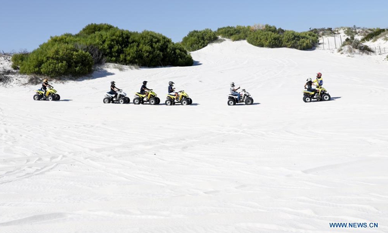 People ride quad bikes on dunes at the Witzands Aquifer Nature Reserve, nothern Cape Town, South Africa, on April 23, 2021. The Witzands Aquifer Nature Reserve is famous for the Atlantis dunes which cover 500 hectares of the reserve. It is a flora and fauna-rich landscape. Below the surface, a large underground natural aquifer supplies the surrounding communities with water. The reserve offers activities such as off-road driving, quad biking and sand boarding.Photo:Xinhua