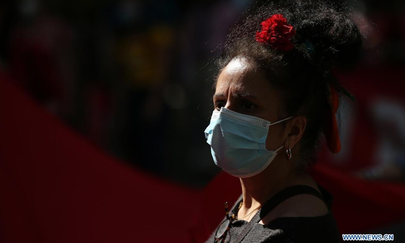 A woman wearing a face mask takes part in a parade to mark the 47th anniversary of the Carnation Revolution amid the COVID-19 pandemic in Lisbon, Portugal, on April 25, 2021. Thousands of people paraded on Sunday in the center of Lisbon to celebrate the 47th anniversary of the Carnation Revolution that overthrew the dictatorship and instituted democracy in the European country in 1974.(Photo: Xinhua)