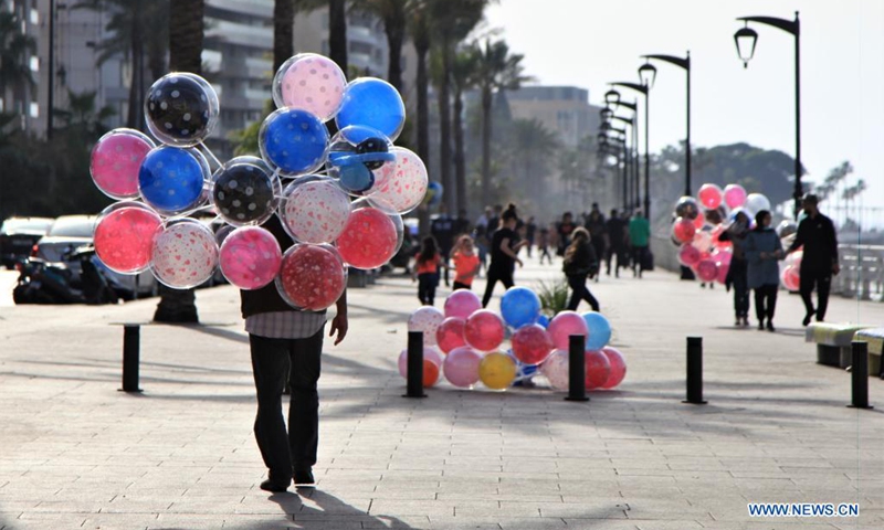 A balloon vendor walks along the Corniche of Beirut, Lebanon, on April 24, 2021.(Photo: Xinhua)