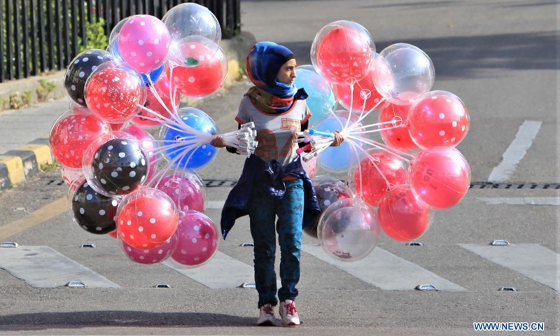 A balloon vendor walks along the Corniche of Beirut, Lebanon, on April 24, 2021.(Photo: Xinhua)