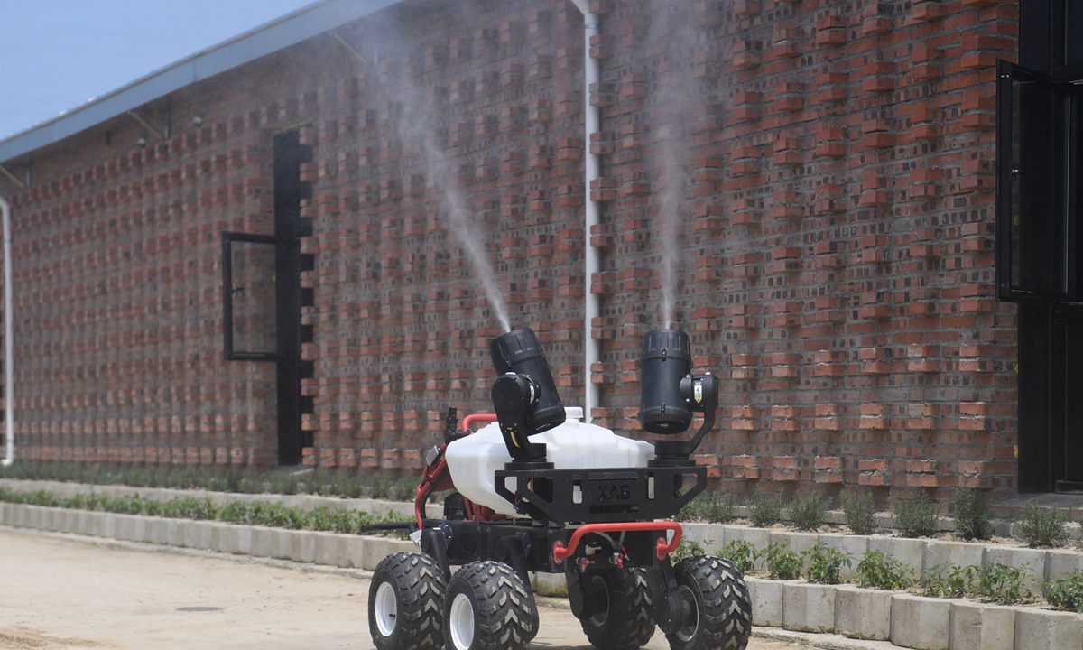 A robot performs daily disinfection work outside a pig-breeding facility in Jiaxing, East China's Zhejiang Province on Monday. Local pig-raising companies are using 5G inspection robots, blockchain applications and other high-tech facilities and equipment to empower their industry. Photo: cnsphoto