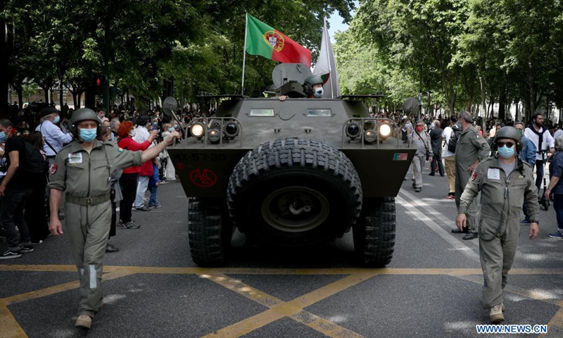 People wearing face masks take part in a parade to mark the 47th anniversary of the Carnation Revolution amid the COVID-19 pandemic in Lisbon, Portugal, on April 25, 2021. Thousands of people paraded on Sunday in the center of Lisbon to celebrate the 47th anniversary of the Carnation Revolution that overthrew the dictatorship and instituted democracy in the European country in 1974.(Photo: Xinhua)