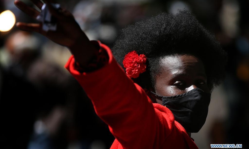 A woman wearing a face mask takes part in a parade to mark the 47th anniversary of the Carnation Revolution amid the COVID-19 pandemic in Lisbon, Portugal, on April 25, 2021. Thousands of people paraded on Sunday in the center of Lisbon to celebrate the 47th anniversary of the Carnation Revolution that overthrew the dictatorship and instituted democracy in the European country in 1974.(Photo: Xinhua)