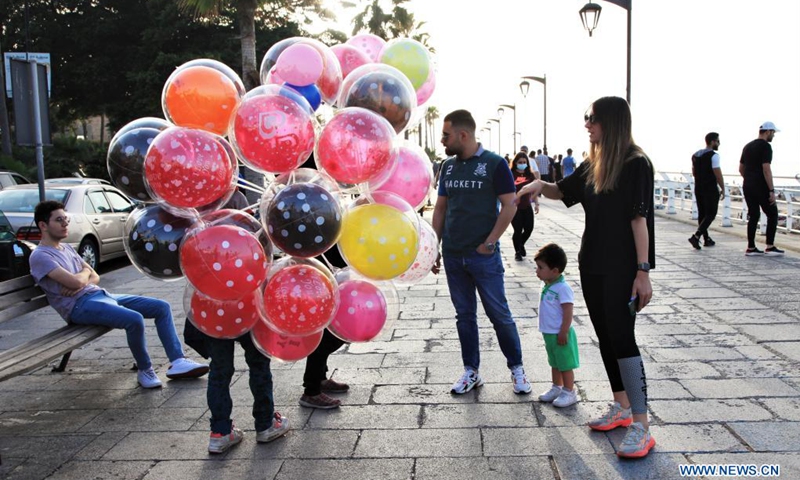 People talk with balloon vendors at the Corniche of Beirut, Lebanon, on April 25, 2021.(Photo: Xinhua)