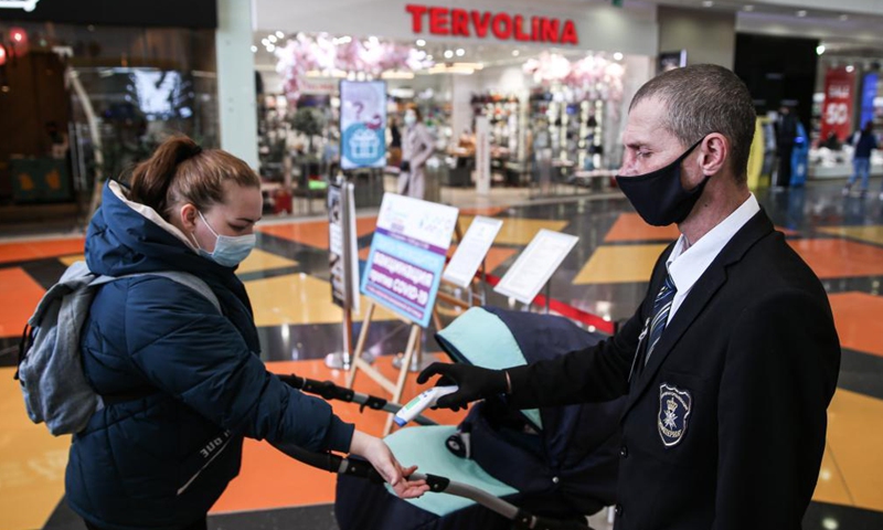 A guard checks the body temperature for a customer at a mall in Moscow, Russia, April 28, 2021. Russia confirmed 7,848 new coronavirus infections over the past 24 hours, below 8,000 for the first time since the end of September, taking the nationwide tally to 4,787,273, the country's official monitoring and response center said Wednesday.Photo:Xinhua