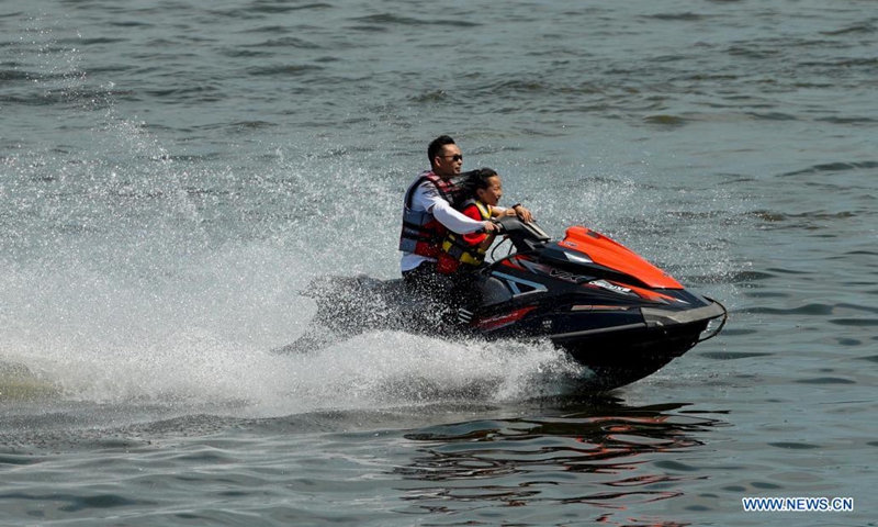 Tourists have fun riding a water scooter at the Changshou Lake scenic area in southwest China's Chongqing, on May 2, 2021. (Xinhua/Liu Chan) 