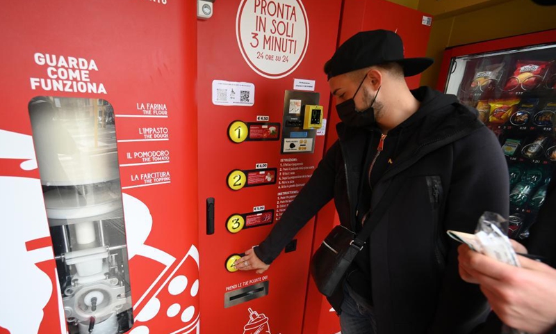 A man orders on an automatic pizza vending machine in downtown Rome, Italy, on May 4, 2021. The vending machine is capable of kneading, seasoning, cooking and delivering the pizza in a carton box in three minutes only.(Photo: Xinhua)