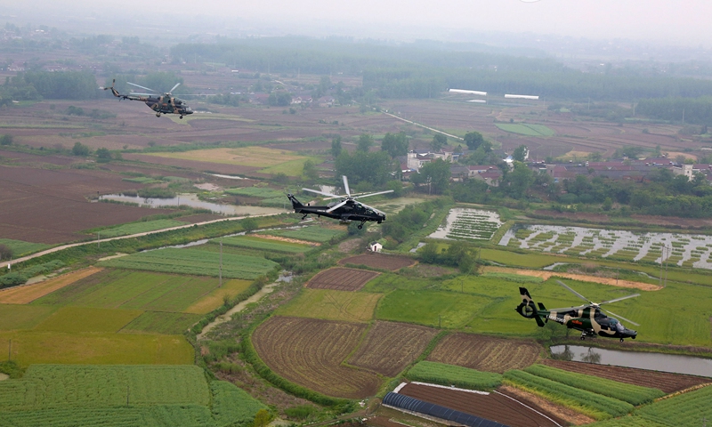 Multi-type helicopters attached to an army aviation brigade under the PLA 72nd Group Army hover over the field during a formation flight training exercise on April 21, 2021. The training focused on subjects including low-altitude maneuver, tactical evading and penetration, and long-range force projection. (eng.chinamil.com.cn/Photo by Sun Mingjian)