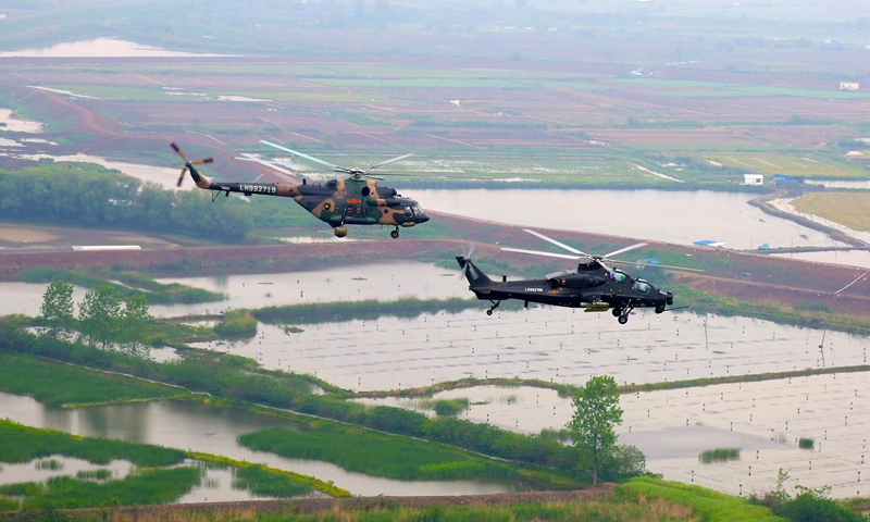 Multi-type helicopters attached to an army aviation brigade under the PLA 72nd Group Army hover over the field during a formation flight training exercise on April 21, 2021. The training focused on subjects including low-altitude maneuver, tactical evading and penetration, and long-range force projection. (eng.chinamil.com.cn/Photo by Sun Mingjian)