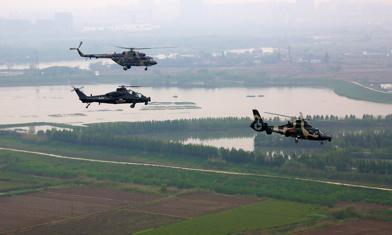 Multi-type helicopters attached to an army aviation brigade under the PLA 72nd Group Army hover over the field during a formation flight training exercise on April 21, 2021. The training focused on subjects including low-altitude maneuver, tactical evading and penetration, and long-range force projection. (eng.chinamil.com.cn/Photo by Sun Mingjian)