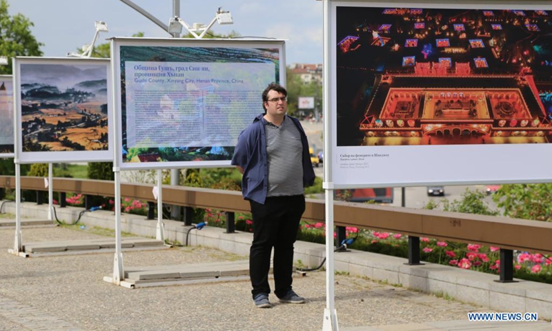 A man looks at a display panel at a photo exhibition entitled Cases of Poverty Alleviation through Tourism in China in Sofia, Bulgaria, on May 5, 2021. The photo exhibition entitled Cases of Poverty Alleviation through Tourism in China opened here on Wednesday.(Photo: Xinhua)