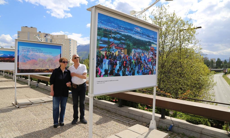 People look at a display panel at a photo exhibition entitled Cases of Poverty Alleviation through Tourism in China in Sofia, Bulgaria, on May 5, 2021. The photo exhibition entitled Cases of Poverty Alleviation through Tourism in China opened here on Wednesday.(Photo: Xinhua)