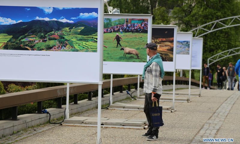 A man looks at a display panel at a photo exhibition entitled Cases of Poverty Alleviation through Tourism in China in Sofia, Bulgaria, on May 5, 2021. The photo exhibition entitled Cases of Poverty Alleviation through Tourism in China opened here on Wednesday.(Photo: Xinhua)