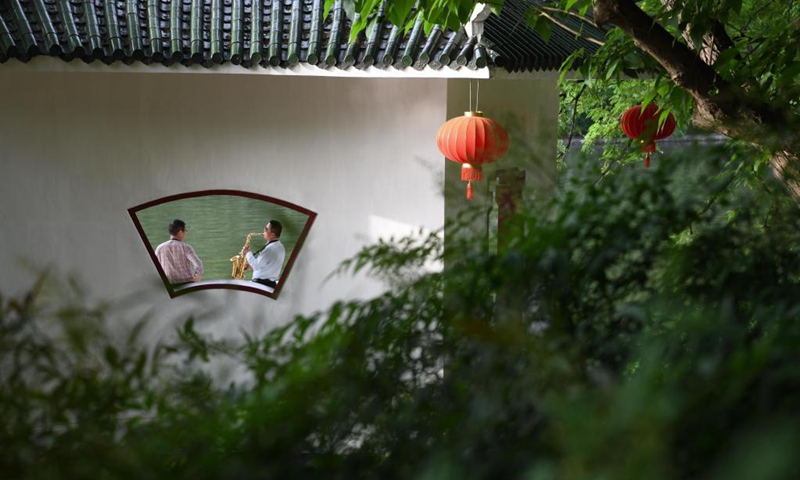 A man plays the saxophone in Huancheng Park in Hefei, capital of east China's Anhui Province, May 5, 2021.(Photo: Xinhua)