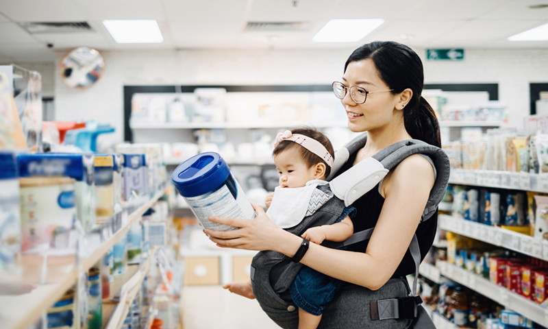 A mum selects infant formula for her child in a supermarket in China. File photo: VCG