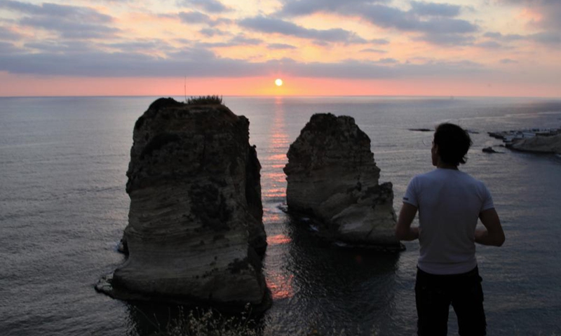 A man watches sunset at Raouche Rocks in Beirut, Lebanon, on May 13, 2021.Photo:Xinhua