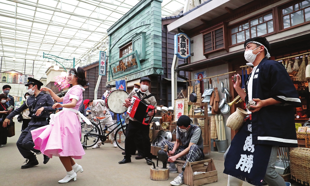 Workers perform at a shopping street that reproduces the Showa era (1926-89) at Seibuen Amusement Park in Tokorozawa, Saitama Prefecture, Japan, on Tuesday. Visitors can enjoy the entertainment of the Showa period, such as 