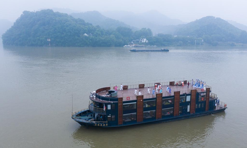 Aerial photo taken on May 19, 2021 shows senior hobbyists of Taijiquan, a traditional Chinese martial art, demonstrating Taijiquan moves on a boat in Fuchunjiang River in Tonglu County, east China's Zhejiang Province. A nation-wide campaign to promote and demonstrate Taijiquan as a fitness exercise among senior citizens was launched here on Wednesday. More than 2,000 Taijiquan hobbyists from all over the country flocked in to participate in the demonstrations and performances.(Photo: Xinhua)