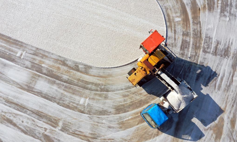 Aerial photo taken on May 18, 2021 shows workers harvesting salt in a salt field at Binhai Township, Zhanhua District, Binzhou City of east China's Shandong Province. Workers have started harvesting spring salt from the 600,000-mu (40,000 hectares) of salt fields at Binhai Township. The total output is expected to hit 500,000 tons when the harvest work concludes by the end of June. Photo:Xinhua