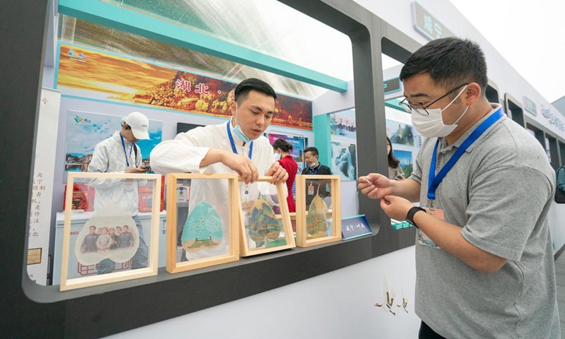 A visitor (R) learns about products on display during the main-site events for the China Tourism Day 2021 at the Hubei Provincial Museum in Wuhan of central China's Hubei Province, on May 19, 2021. Main-site events for the China Tourism Day 2021 kicked off on Wednesday at the Hubei Provincial Museum under the theme of green development, better life.  (Photo: Xinhua)