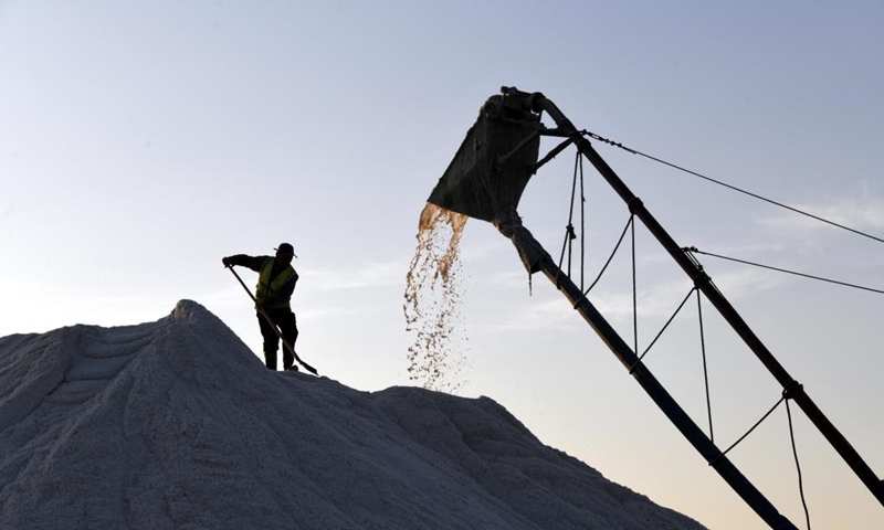 A worker operates on a salt pile in a salt field at Binhai Township, Zhanhua District, Binzhou City of east China's Shandong Province, on May 18, 2021. Workers have started harvesting spring salt from the 600,000-mu (40,000 hectares) of salt fields at Binhai Township. The total output is expected to hit 500,000 tons when the harvest work concludes by the end of June. Photo:Xinhua