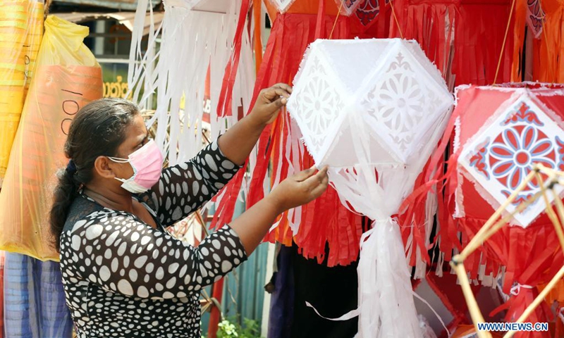 A vendor wearing a face mask prepares to sell lanterns ahead of the Vesak festival in Colombo, Sri Lanka, on May 19, 2021. The Vesak Festival is one of the holiest festivals celebrated in Sri Lanka as it marks the birth, enlightenment and demise of Lord Buddha.(Photo: Xinhua)