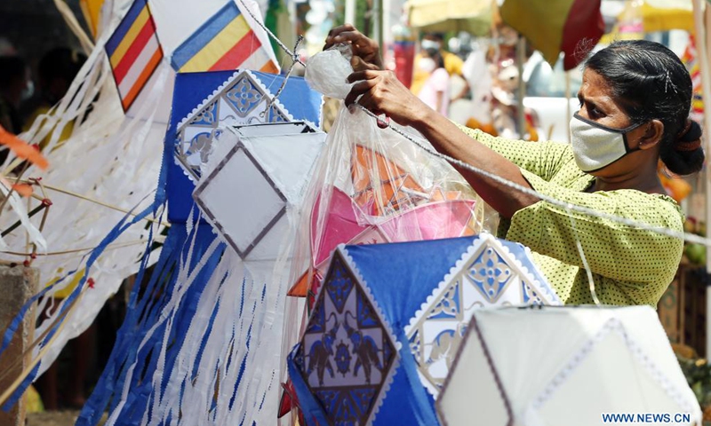 A vendor wearing a face mask prepares to sell lanterns ahead of the Vesak festival in Colombo, Sri Lanka, on May 19, 2021. The Vesak Festival is one of the holiest festivals celebrated in Sri Lanka as it marks the birth, enlightenment and demise of Lord Buddha.(Photo: Xinhua)