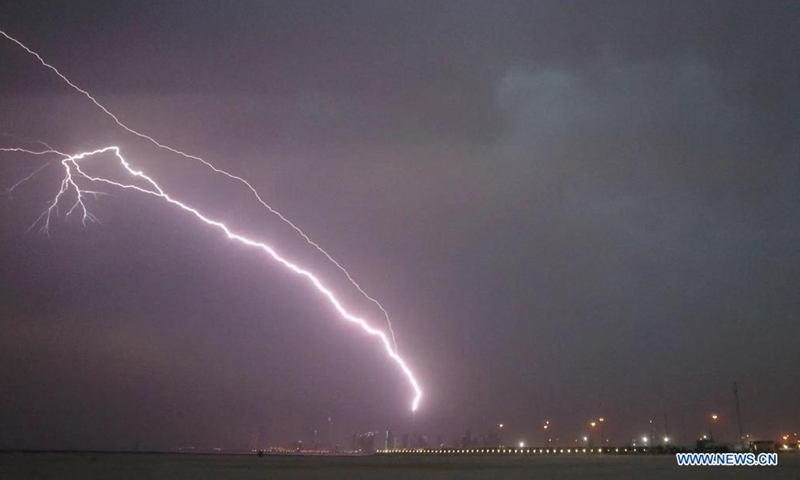 Photo taken on May 24, 2021 shows lightning bolts over the skyline of Kuwait City, Kuwait. (Photo by Asad/Xinhua)