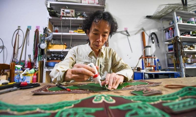 Xilinhu makes a saddle-shaped handicraft at his workshop in Xilinhot, north China's Inner Mongolia Autonomous Region, May 26, 2021. Horse riding, archery and wrestling are called men's three skills of the Mongolian ethnic group. Since 2005, handicraftsman Xilinhu of the Mongolian ethnic group has involved the cultural symbols of saddle, bow and arrow and wrestling costume into handicrafts making to promote traditional culture of the ethnic group.  Photo: Xinhua