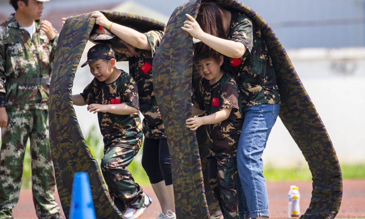 Children and parents cooperate in a military-themed sports game in Taizhou. Photo: IC