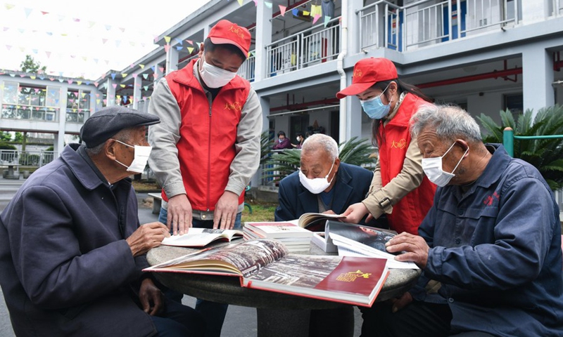 Senior residents are accompanied on reading by volunteers at a nursing home in Yuyao, east China's Zhejiang Province, April 21, 2020.Volunteers brought more than donated 100 books to the elderly living in the nursing home as the World Book Day approaches.(Photo: Xinhua)