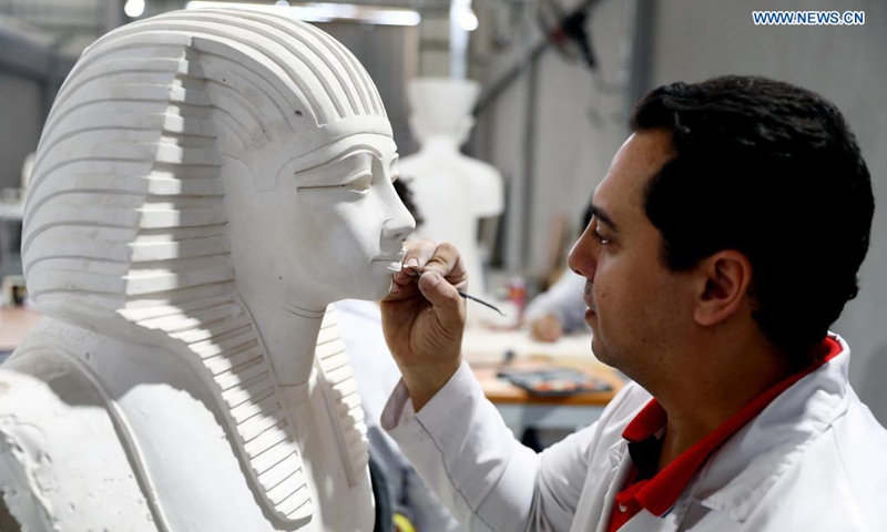 13 April 2021, Egypt, Obour City: A craftsman works on a model replica of  an ancient Egyptian statue, at Konouz factory, the first factory in the  region for archaeological reproductions. The antique