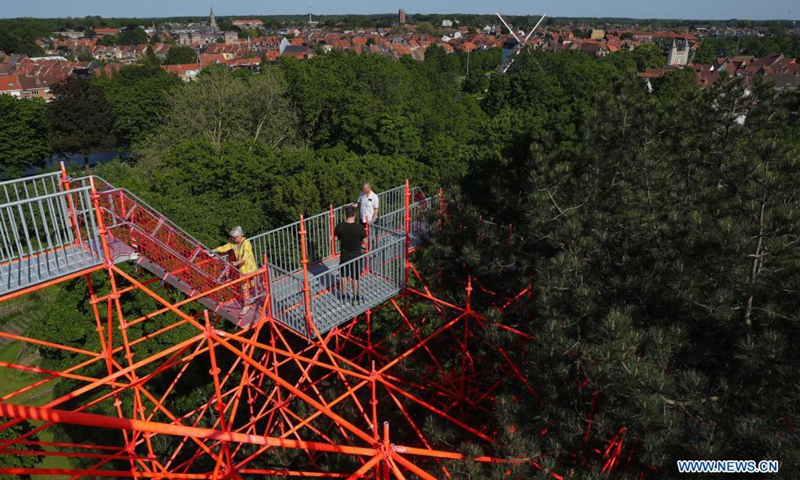 People experience the art installation Strangler by Hector Zamora in Bruges, Belgium, June 1, 2021. From May 8 to Oct. 24, the third Triennial Bruges brings contemporary art and architecture to the city with rich history. With the theme TraumA, art pieces created by thirteen artists and architects were shown in different places in the city.(Photo: Xinhua)