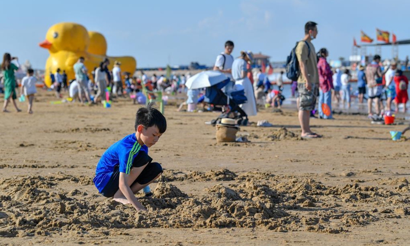 A child plays with sand at an artificial beach resort at Dongjiang Port in the Binhai New Area of north China's Tianjin, June 5, 2021. Photo: Xinhua 