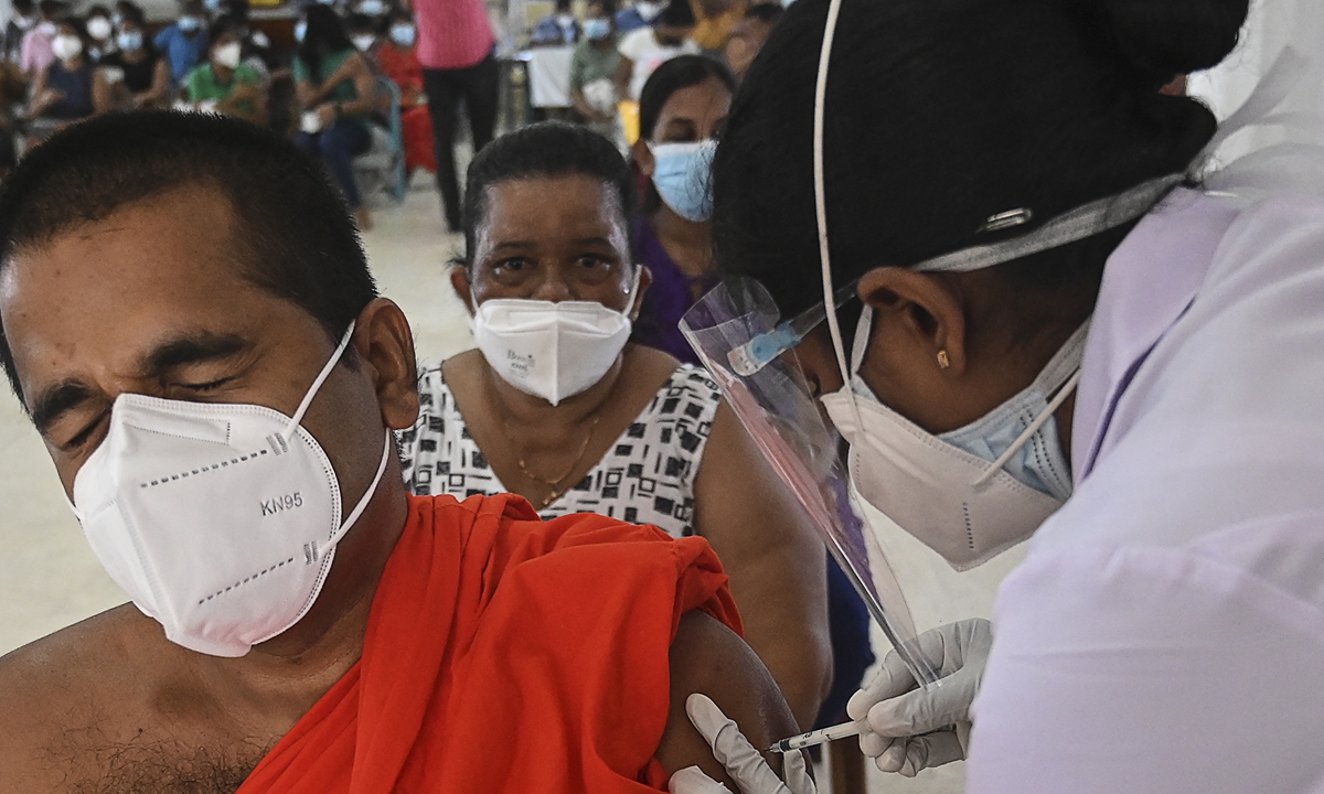 A health worker inoculates a Buddhist monk with a dose of the Chinese-made Sinopharm COVID-19 vaccine in Colombo,  Sri Lanka on Tuesday. The country reported more than 226,000 coronavirus infections as of Tuesday, with more than 2,260 deaths. Photo: AFP