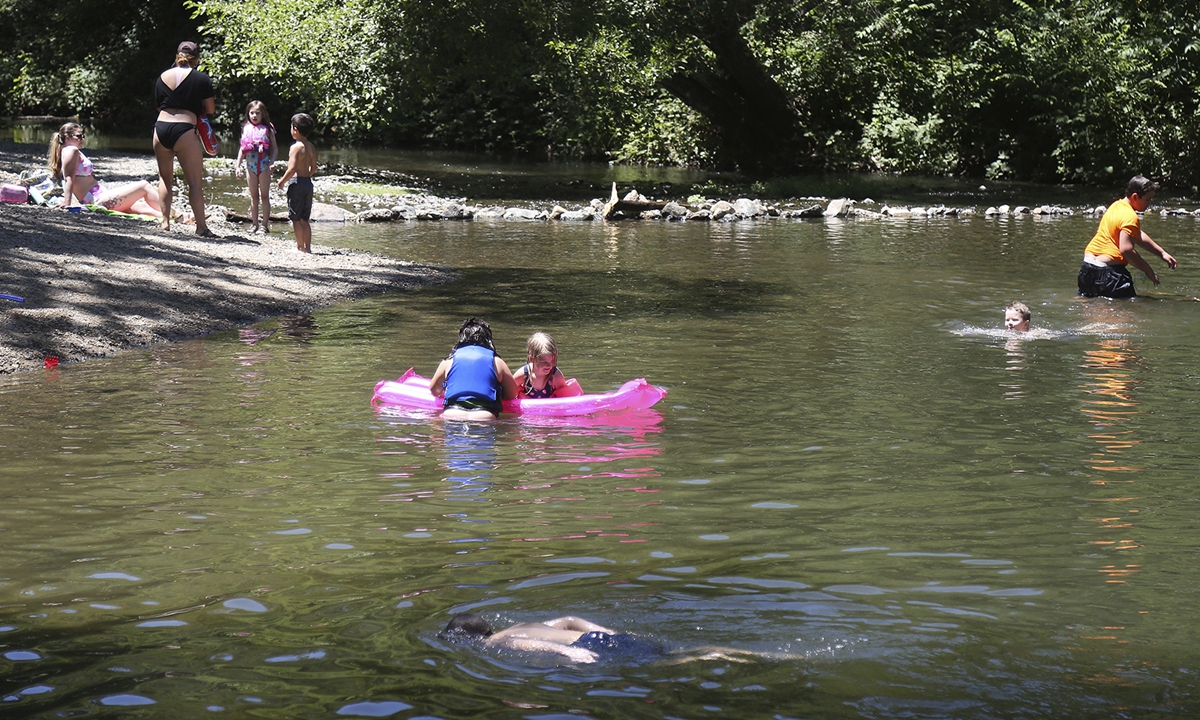 Families beat the heat in the calm and shallow waters of Squirrel Creek Tuesday afternoon in Western Gateway Park in Penn Valley, California. Photo: VCG