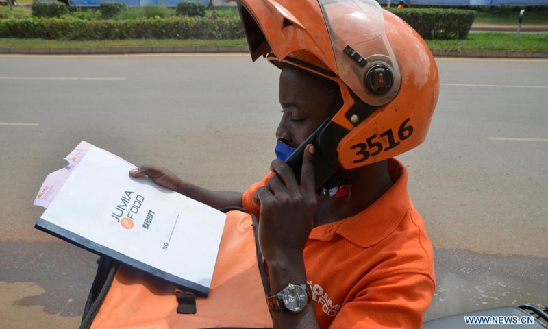 A delivery man calls his customer in Kampala, Uganda, June 21, 2021. In Uganda, delivery business has stepped up online services as a measure to curb the spread of coronavirus.(Photo: Xinhua)