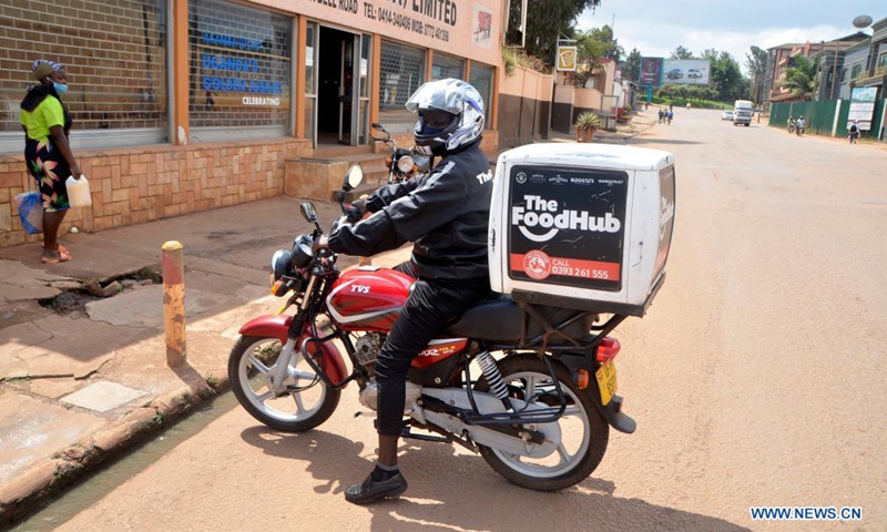 A delivery man delivers food to a customer in Kampala, Uganda, June 21, 2021. In Uganda, delivery business has stepped up online services as a measure to curb the spread of coronavirus.(Photo: Xinhua)