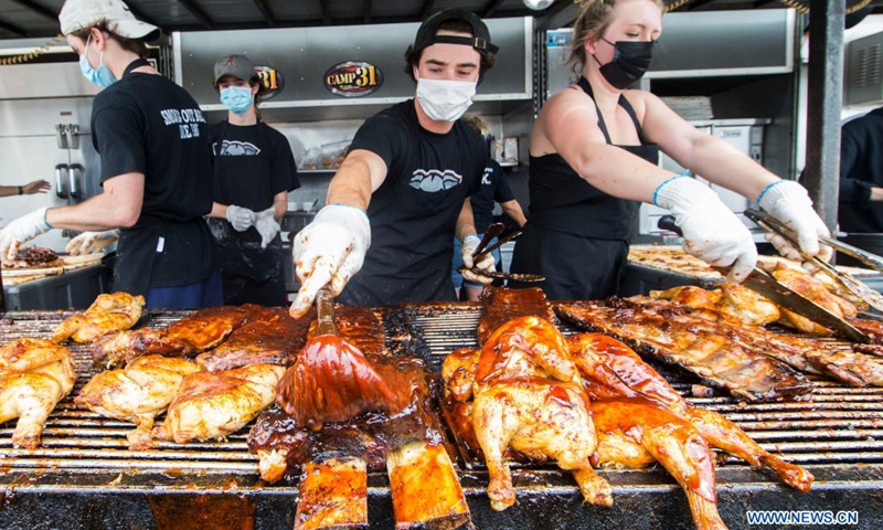 Barbecuers wearing face masks prepare ribs during the 2021 Mississauga Ribfest drive-thru event in Mississauga, Ontario, Canada, on June 26, 2021. The drive-thru event is held here from Friday to Sunday.(Photo: Xinhua)