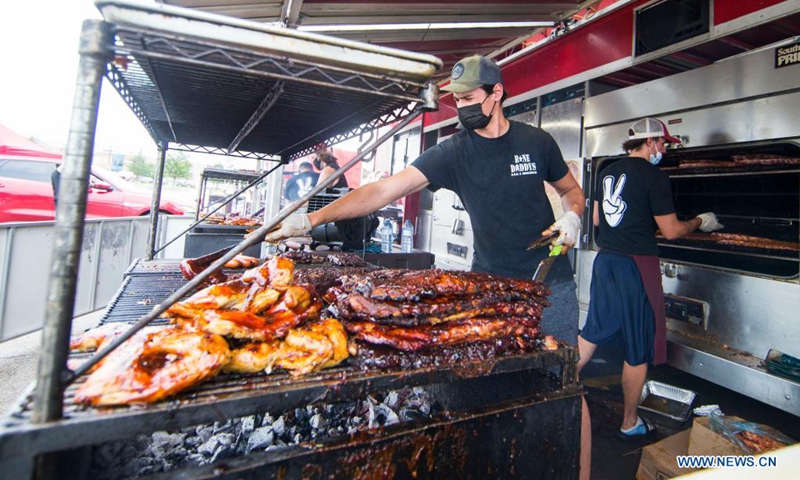 A barbecuer wearing a face mask prepares ribs during the 2021 Mississauga Ribfest drive-thru event in Mississauga, Ontario, Canada, on June 26, 2021. The drive-thru event is held here from Friday to Sunday.(Photo: Xinhua)