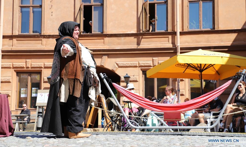 A performer shows her medieval-style costume to audience at the annual Medieval Market in Turku, Finland, July 1, 2021. The annual Medieval Market, one of the largest historical events in Finland, is held in Turku from July 1 to July 4. Due to the COVID-19 pandemic, this year's scale has been reduced and the number of visitors are severely restricted.Photo:Xinhua