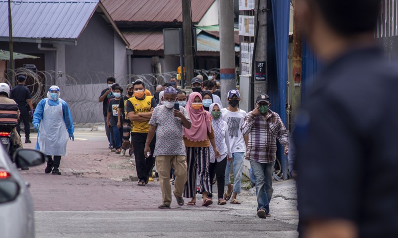 People wearing face masks wait for swab tests at an area subject to more restrictive movement control measures to curb COVID-19 in Kuala Lumpur, Malaysia, July 3, 2021.(Photo: Xinhua)