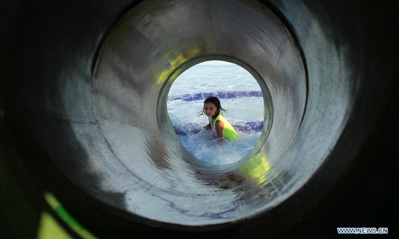 A Palestinian girl plays in a pool to cool off during a hot day at Sharm Park Resort in Gaza City, on July 4, 2021.(Photo: Xinhua)