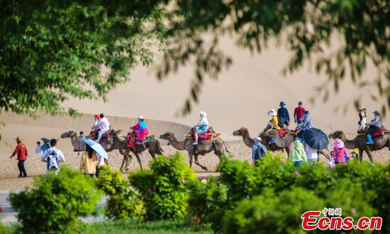 Visitors enjoy the Crescent Lake scenic spot in Dunhuang, Gansu Province. (Photo/ Wang Binyin)