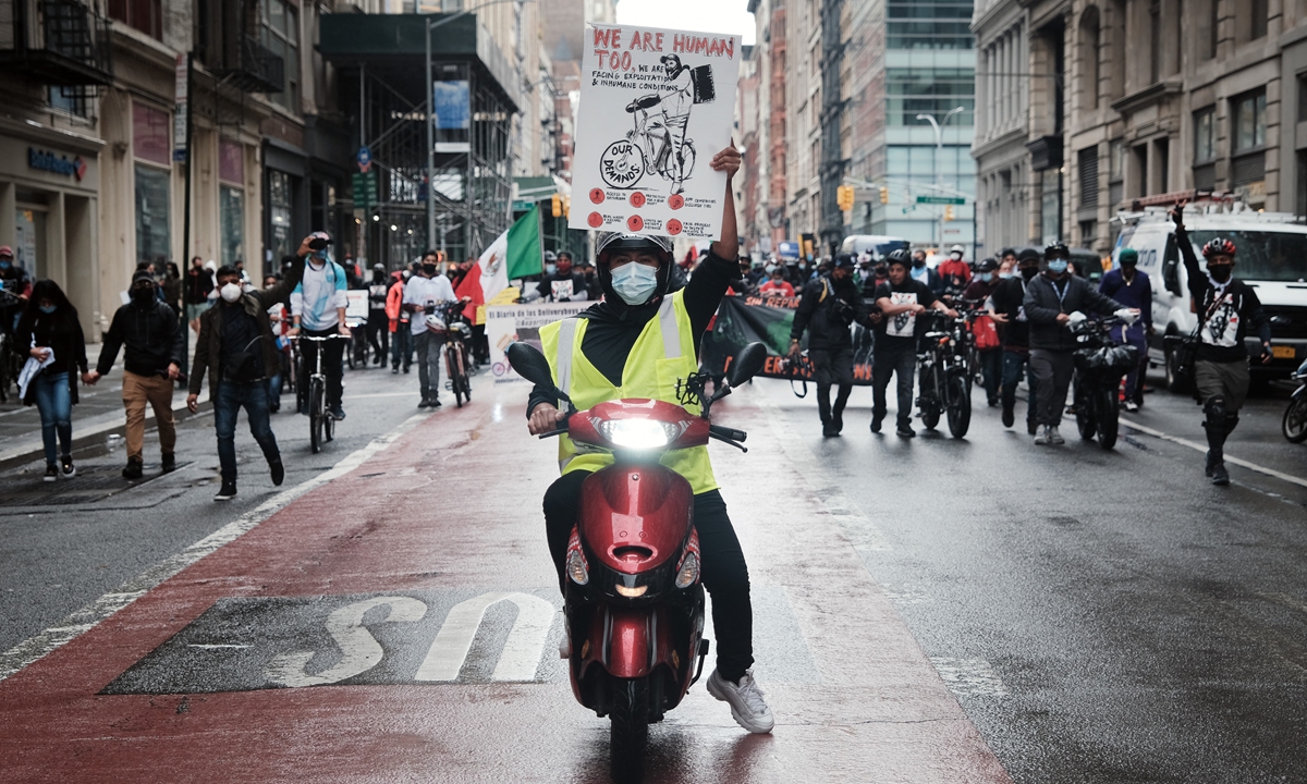 Hundreds of delivery workers, many of them immigrants, participate in a protest and march down Broadway to City Hall on April 21 in New York. Photo: AFP