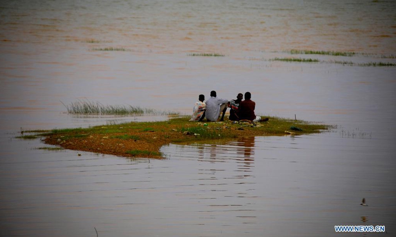 People sit on the river bank of the Nile during the rainy season in Khartoum, Sudan, on July 25, 2021.(Photo: Xinhua)