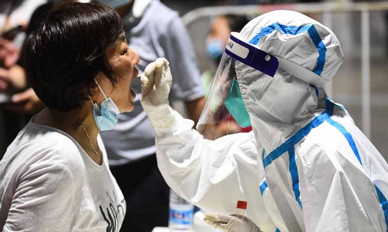 A medical worker takes a swab sample from a woman for COVID-19 test at a testing site in Nanjing, east China's Jiangsu Province, July 21, 2021. Photo: Xinhua 