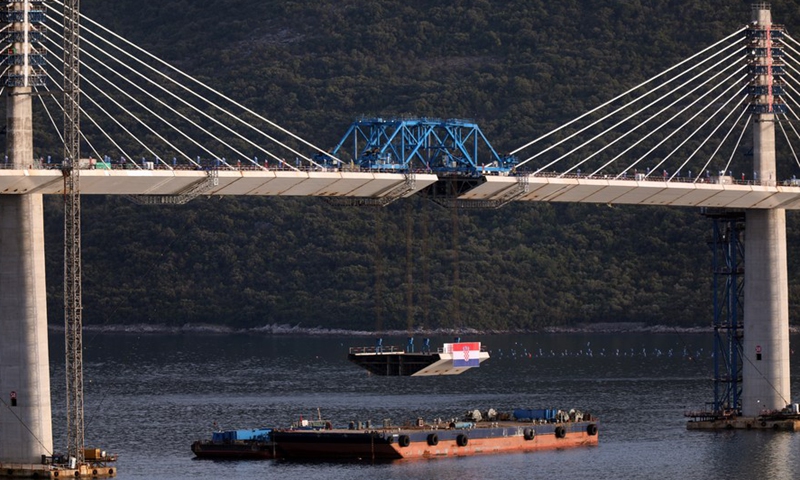 Photo taken on July 28, 2021 shows the final piece of steel box girder being lifted at Mali Ston Bay near Komarna of southern Croatia.Photo:Xinhua