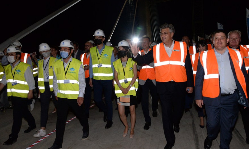 Croatian Prime Minister Andrej Plenkovic waves to Chinese workers as he walks on the Peljesac Bridge to attend a ceremony marking the connection of the bridge near Komarna of southern Croatia, July 29, 2021.Photo:Xinhua