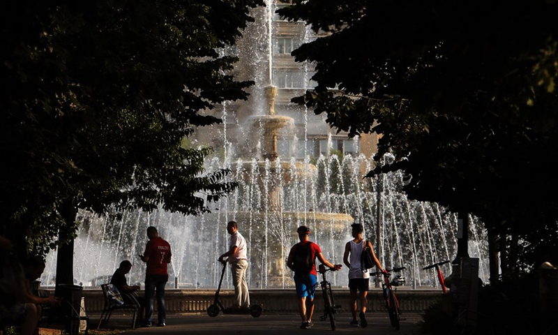 People are seen beside a fountain during a hot day in downtown Bucharest, Romania, on July 28, 2021.Photo:Xinhua